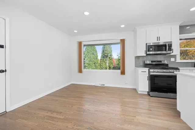 a kitchen with stainless steel appliances a stove top oven a sink and a window