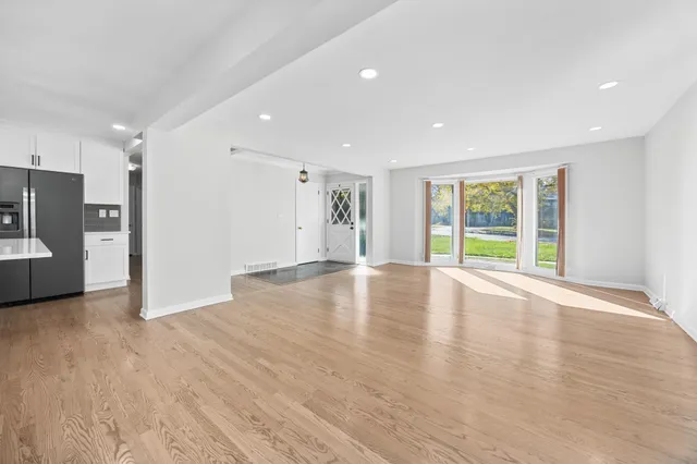 a view of empty room with wooden floor and fireplace