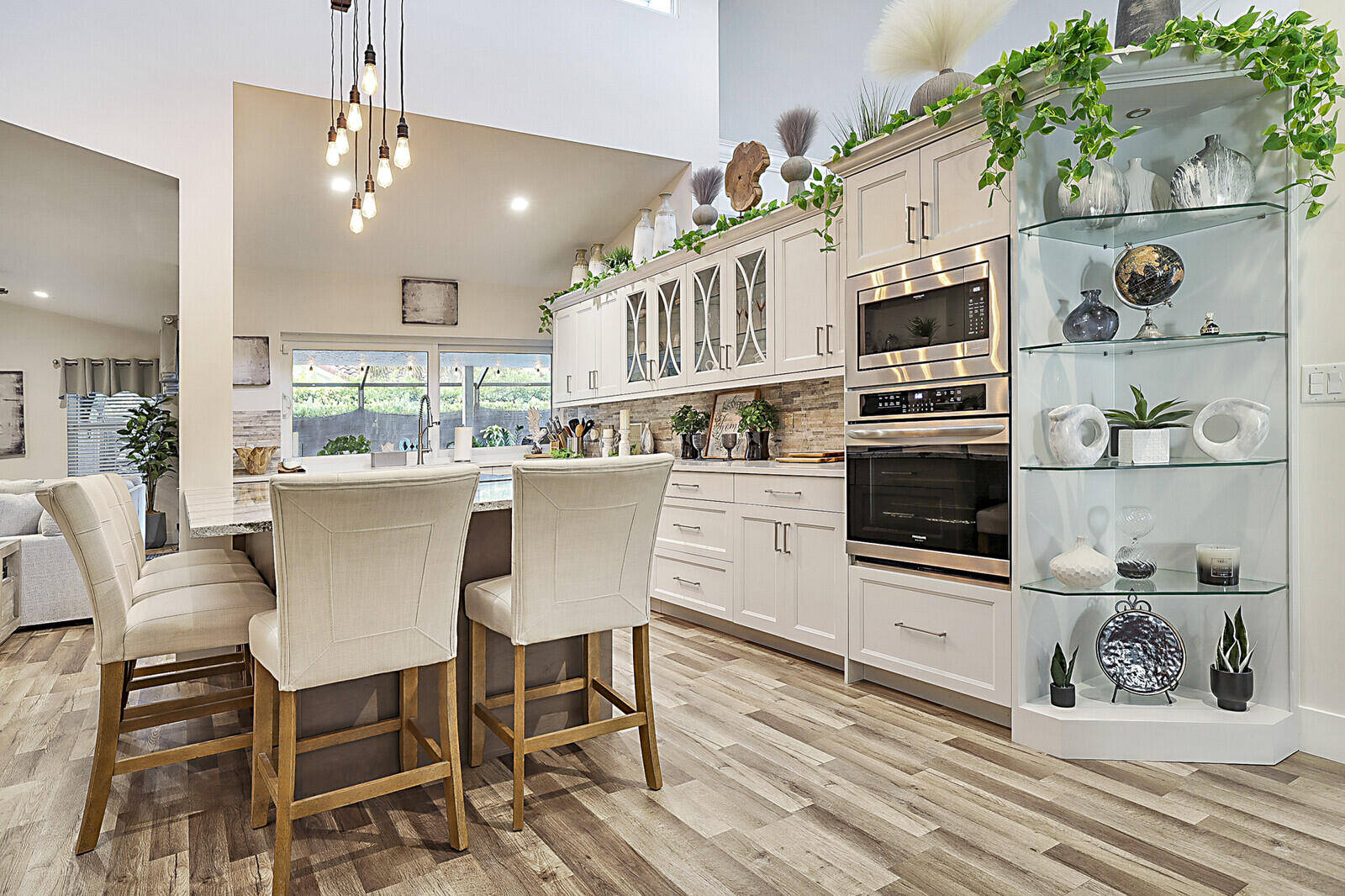 2155 Rabbit Hollowe Circle Delray Beach, FL 33445 - Photo 11 of 71 a kitchen with stainless steel appliances kitchen island granite countertop a stove a sink a dining table and chairs with wooden floor