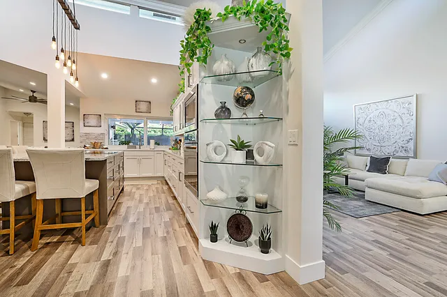 a view of a hallway with wooden floor and a bathroom