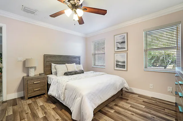 a view of a white house with a big yard and large trees