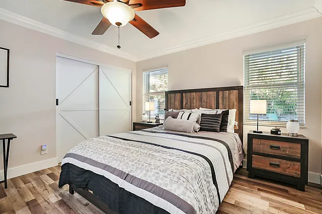 a view of white house with a big yard and palm trees