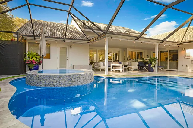 a view of a swimming pool with chairs in patio