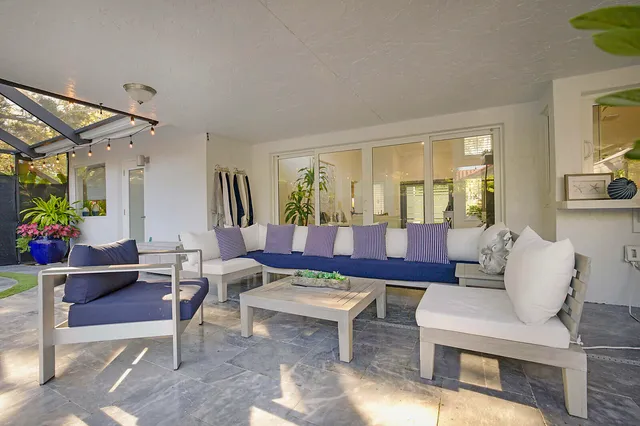 a view of a house with a yard potted plants and a fountain