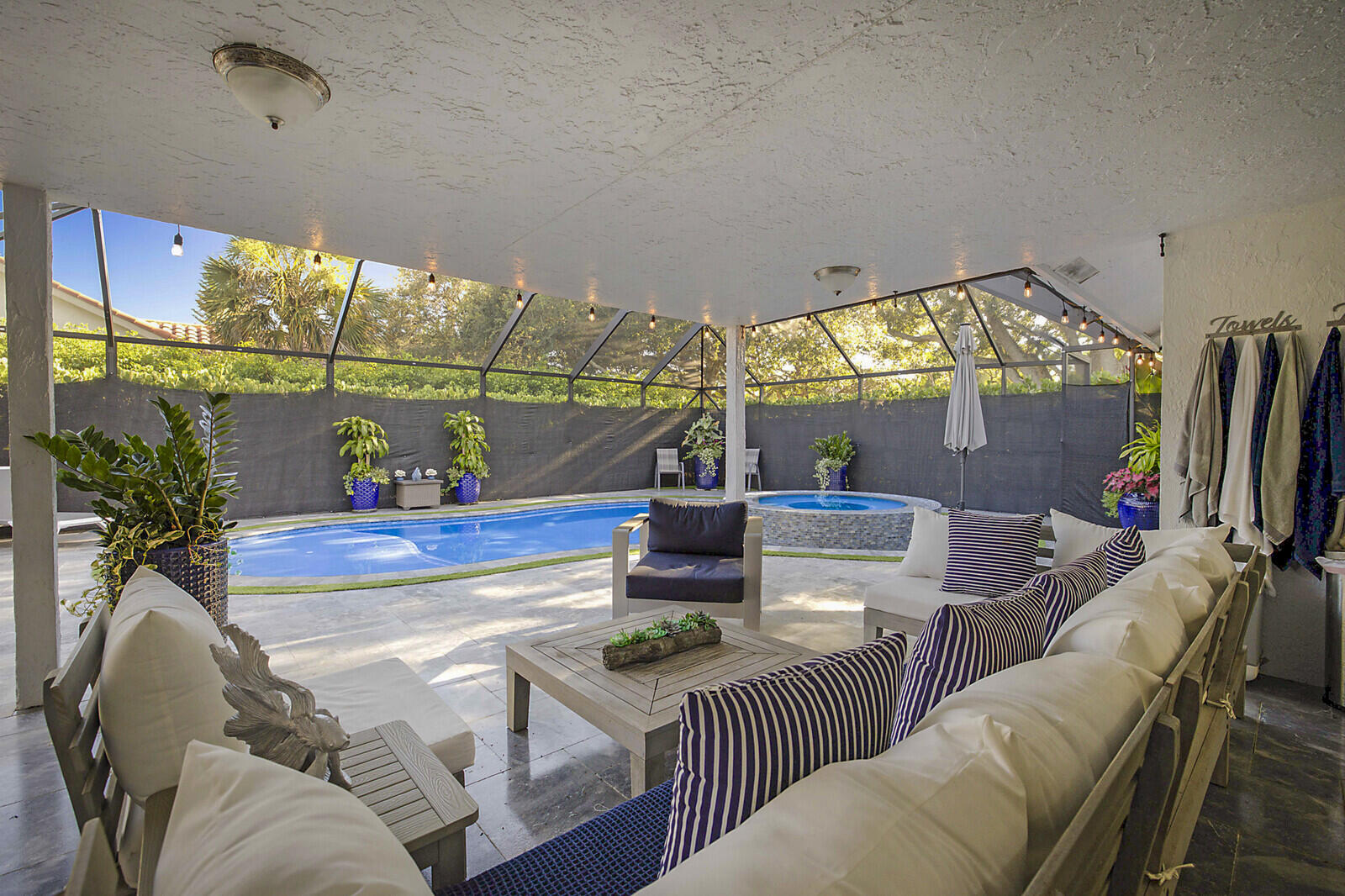 2155 Rabbit Hollowe Circle Delray Beach, FL 33445 - Photo 46 of 71 a living room with furniture a flat screen tv and a floor to ceiling window