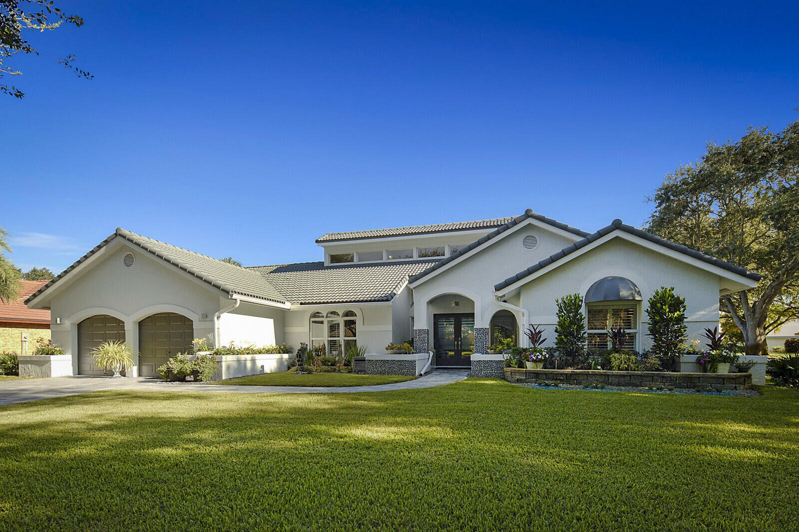 2155 Rabbit Hollowe Circle Delray Beach, FL 33445 - Photo 52 of 71 a view of a white house with a big yard and large trees