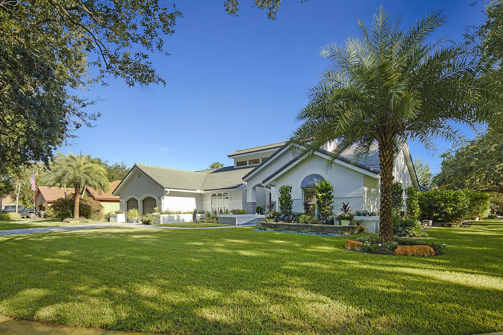 2155 Rabbit Hollowe Circle Delray Beach, FL 33445 - Photo 53 of 71 a view of white house with a big yard and palm trees