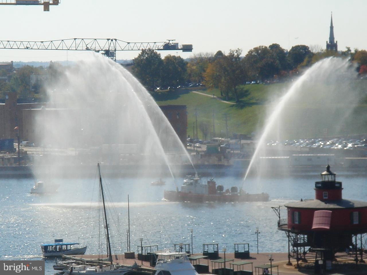 250 President Street, Unit 609 Baltimore, MD 21202 - Photo 22 of 28 Waterworks display over serene harbor scene.