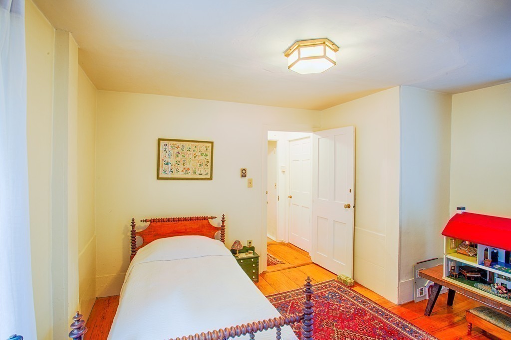 938 Bay Road Hamilton, MA 01982 - Photo 23 of 30 a bedroom with a bed and a chandelier