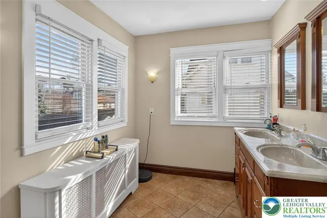 a bathroom with a granite countertop sink and a window
