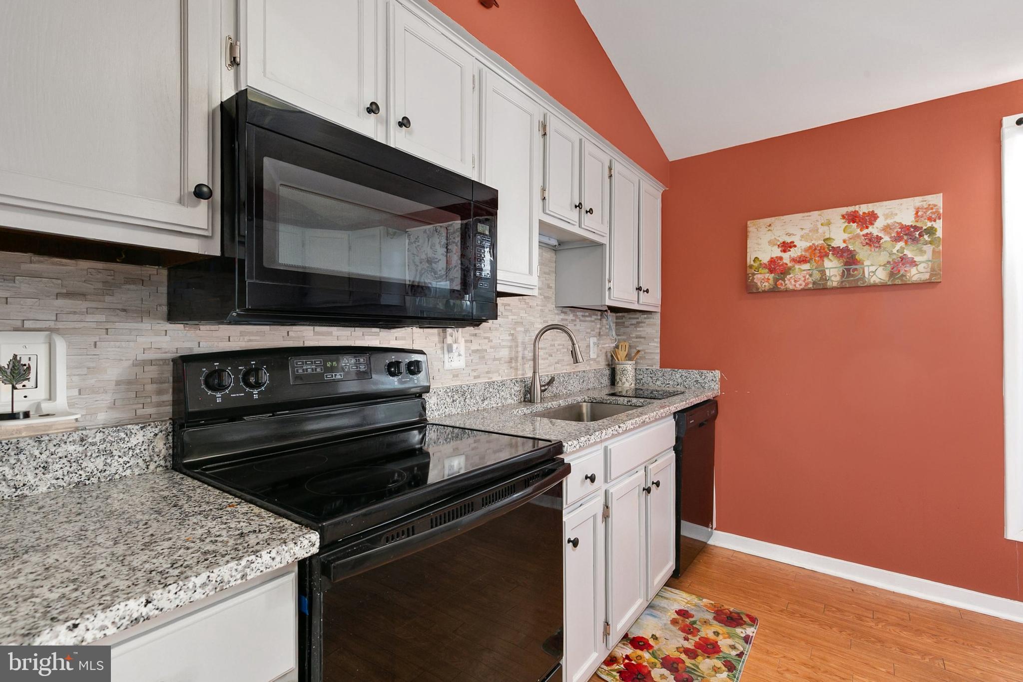 9348 Windbell Way Columbia, MD 21045 - Photo 11 of 37 a kitchen with stainless steel appliances a stove microwave and sink