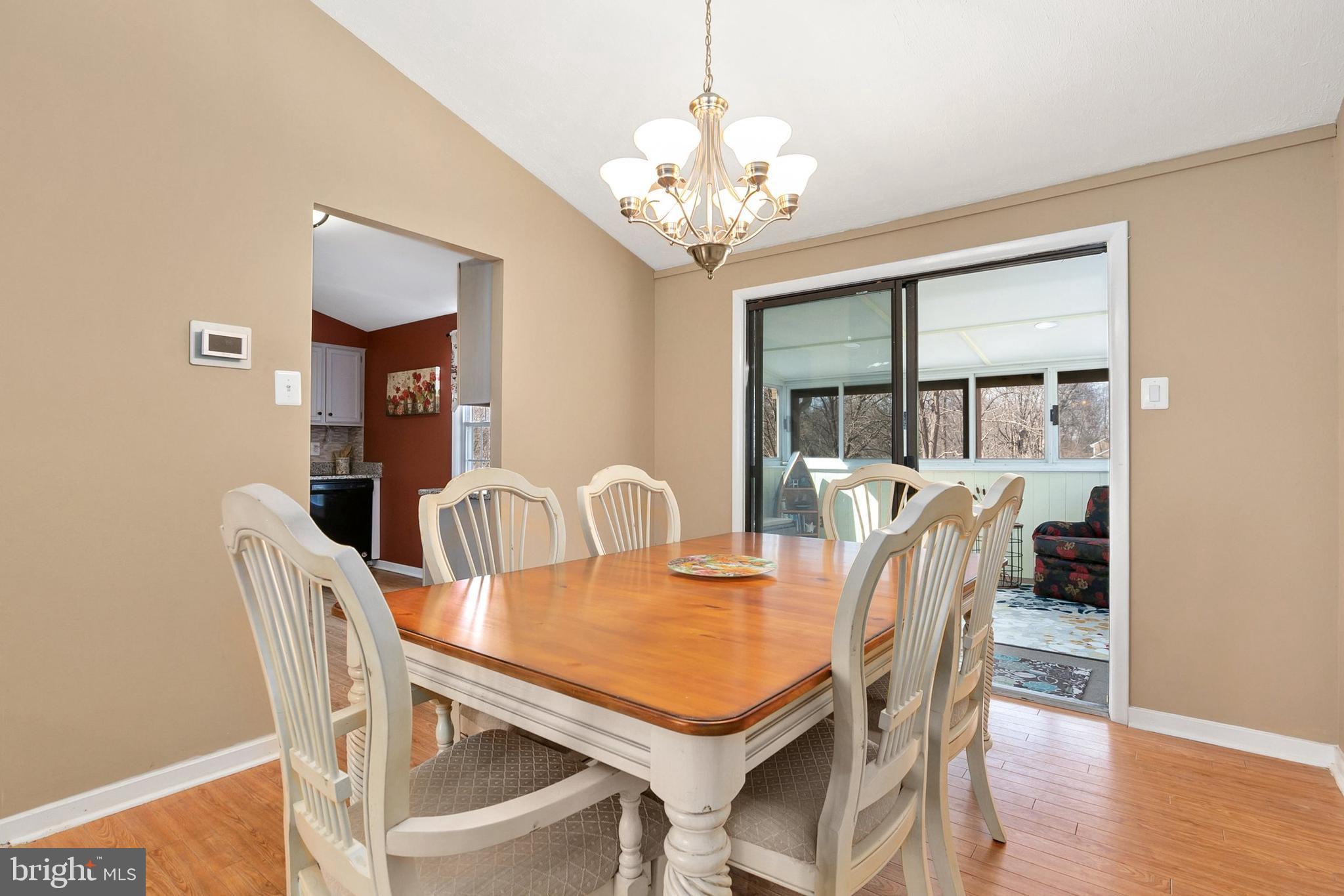 9348 Windbell Way Columbia, MD 21045 - Photo 8 of 37 a dining room with furniture a chandelier and wooden floor