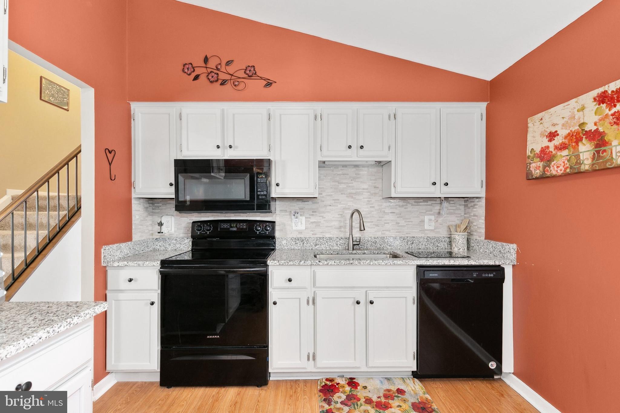 9348 Windbell Way Columbia, MD 21045 - Photo 10 of 37 a kitchen with stainless steel appliances granite countertop a stove a sink and a microwave