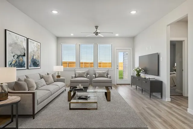 a living room with furniture flat screen tv and window