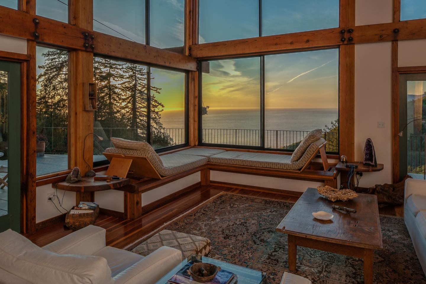 29141 Plasket Ridge Road Big Sur, CA 93920 - Photo 14 of 48 a living room with hardwood floor and large windows