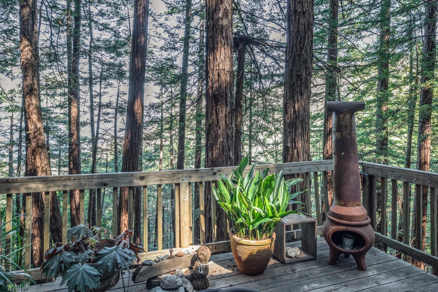 29141 Plasket Ridge Road Big Sur, CA 93920 - Photo 35 of 48 a view of a balcony with chairs potted plants and large tree