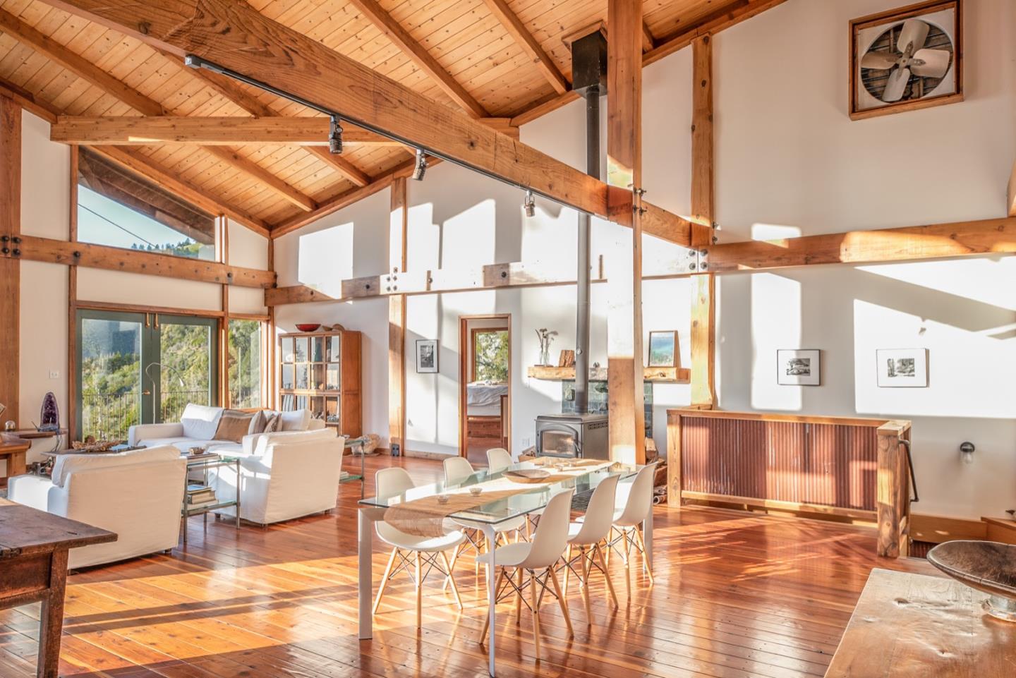 29141 Plasket Ridge Road Big Sur, CA 93920 - Photo 4 of 48 a living room with couches and kitchen view with wooden floor