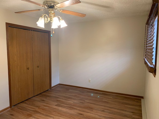 507 Jenkran Street, Unit 4 Morrison, IL 61270 - Photo 7 of 11 an empty room with wooden floor fan and windows