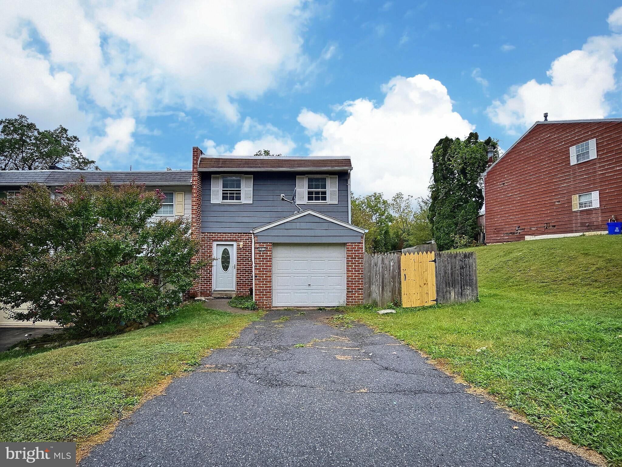 a front view of a house with yard and green space