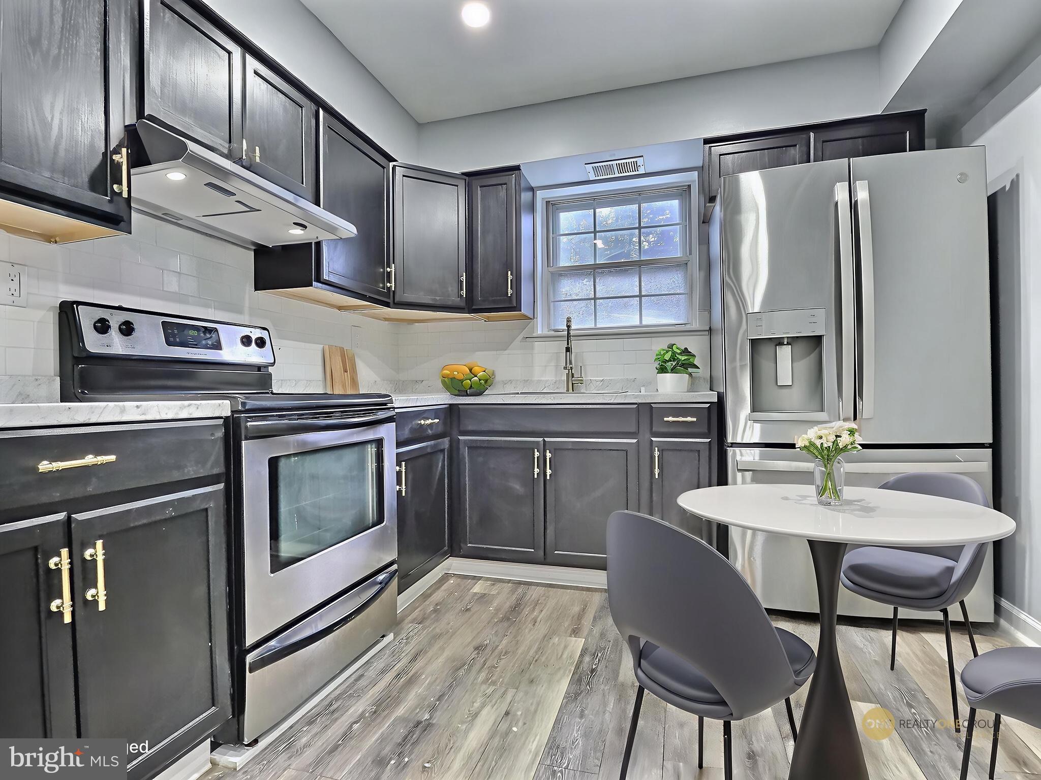 1213 Deer Run Reading, PA 19606 - Photo 18 of 42 a kitchen with stainless steel appliances a stove a sink island and chairs