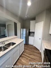 a view of a kitchen with a sink and refrigerator