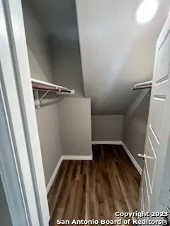 a view of walk in closet with wooden floor