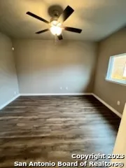 en empty room with wooden floor and windows