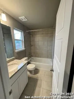 a bathroom with a granite countertop sink a toilet and shower