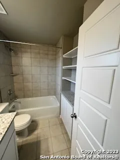 a bathroom with a granite countertop bathtub shower sink and toilet