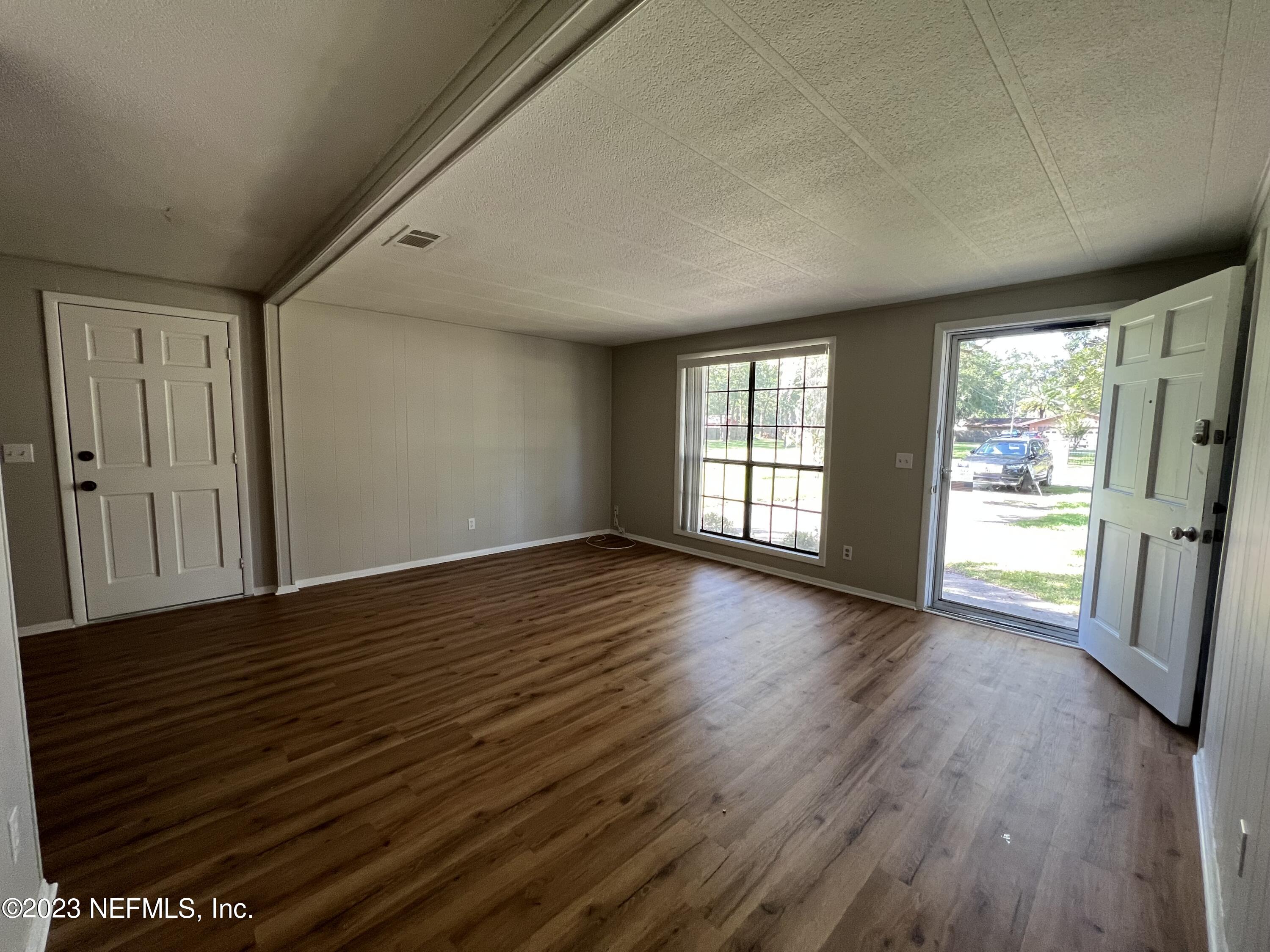 765 Ebb Tide Drive Fleming Island, FL 32003 - Photo 4 of 15 an empty room with wooden floor and windows