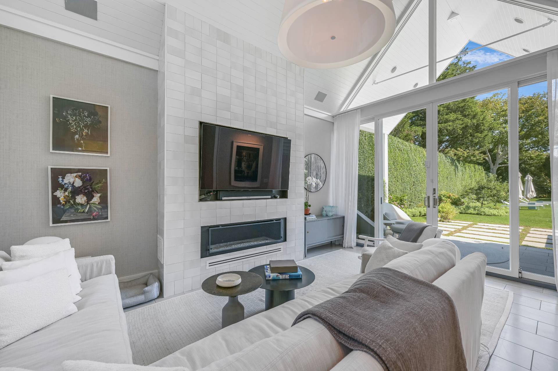 Undisclosed Address Bridgehampton, NY 11932 - Photo 20 of 35 a living room with furniture a flat screen tv and a floor to ceiling window