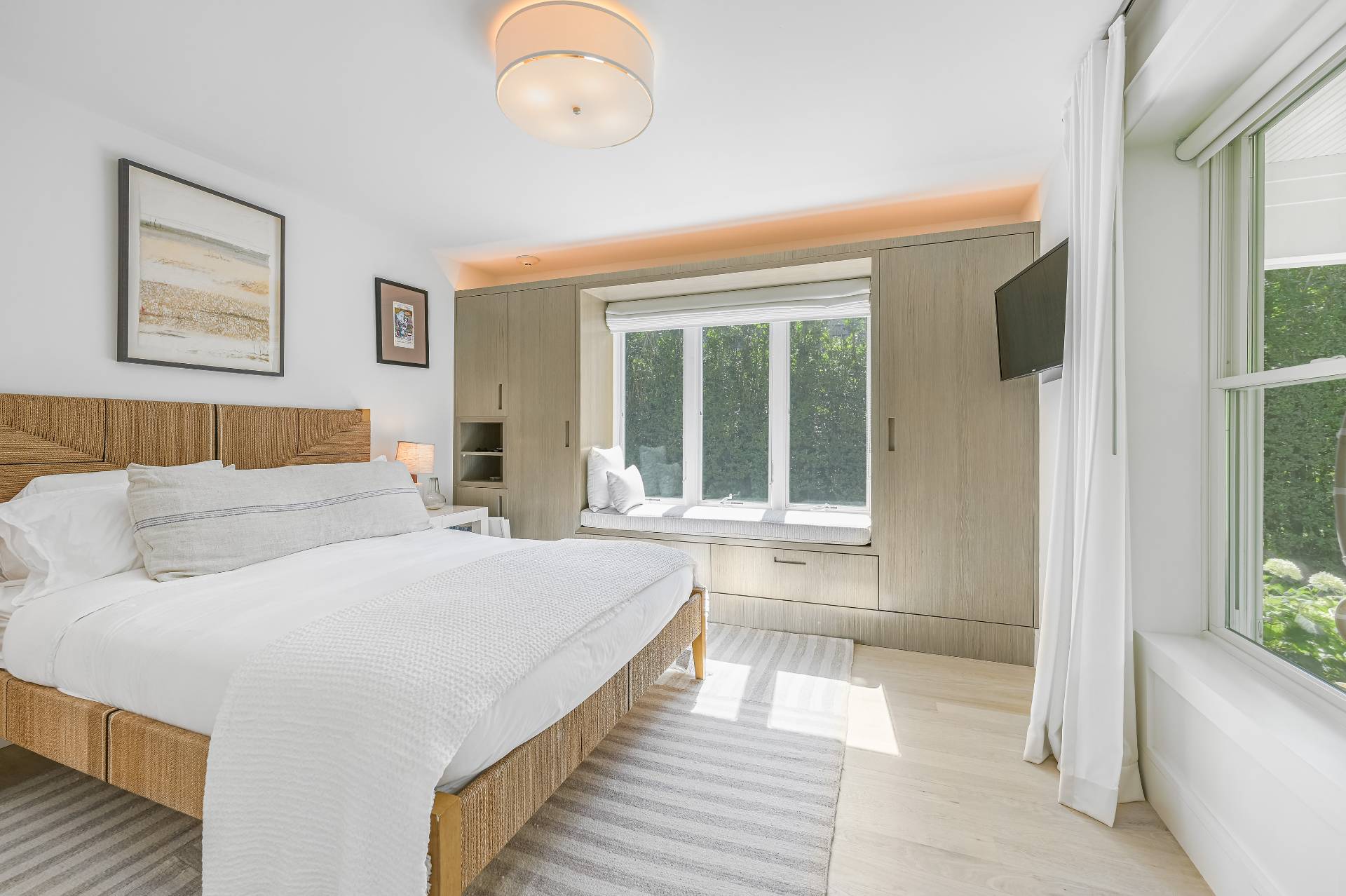 Undisclosed Address Bridgehampton, NY 11932 - Photo 22 of 35 a spacious bedroom with a large bed and a large window