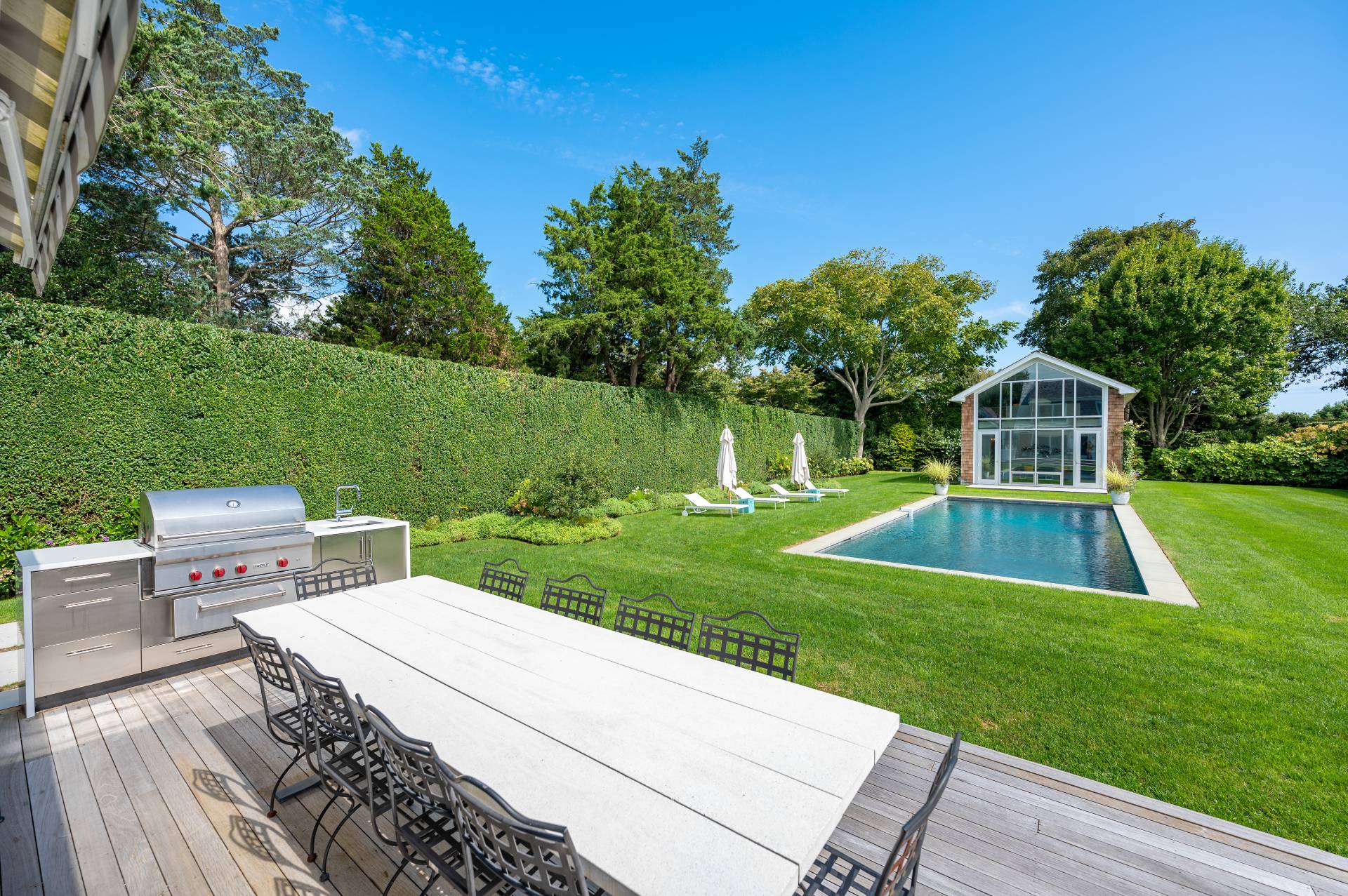 Undisclosed Address Bridgehampton, NY 11932 - Photo 10 of 35 a view of a backyard with table and chairs potted plants and large tree
