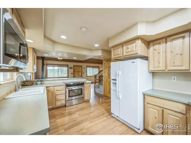 a kitchen with refrigerator cabinets and wooden floor