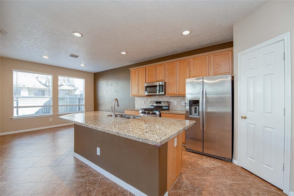 a kitchen with stainless steel appliances granite countertop refrigerator a sink a stove and cabinets