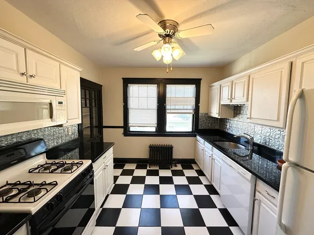 a kitchen with a stove a sink and a window