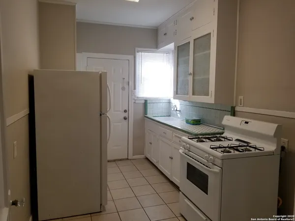 a kitchen with granite countertop a sink cabinets and stainless steel appliances