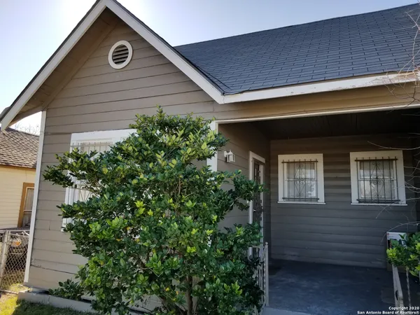 a front view of a house with plants