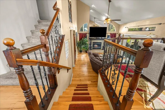 a hallway with wooden floor stairs and furniture