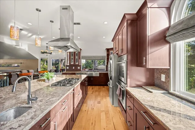 a kitchen with stainless steel appliances granite countertop sink stove and refrigerator