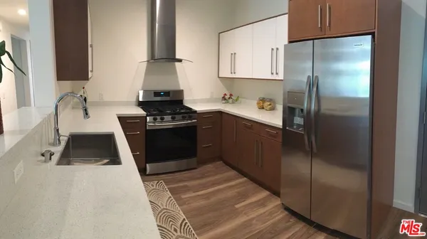 a kitchen with stainless steel appliances granite countertop a stove a refrigerator and a sink