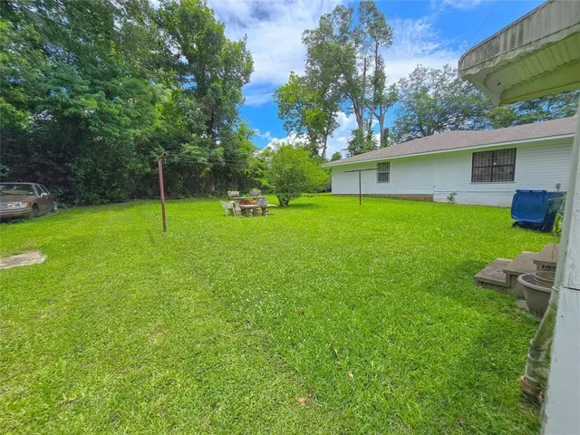 a view of a house with a backyard and a tree