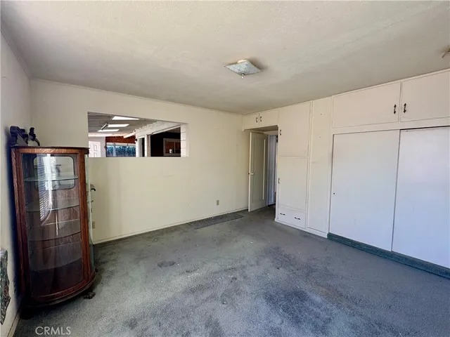 a view of a livingroom with an empty space and a refrigerator