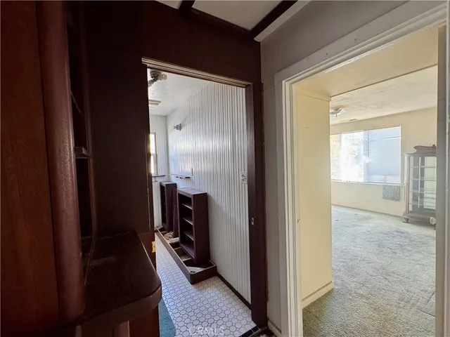 a view of a hallway and a livingroom with furniture