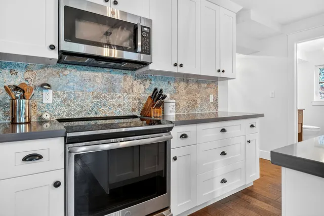 a view of entryway and kitchen with wooden floor