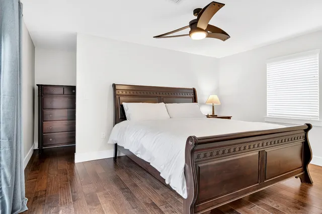 a bedroom with a bed and wooden floor