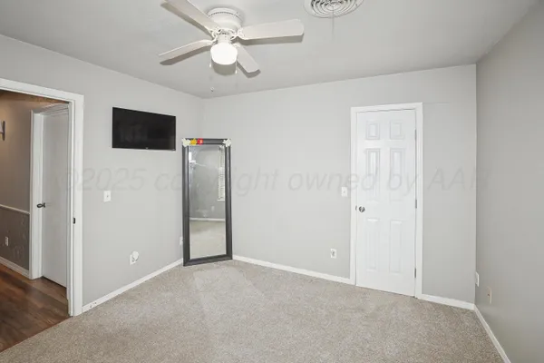 an empty room with closet and a ceiling fan