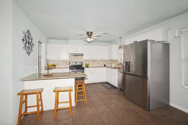 a kitchen with white cabinets and stainless steel appliances