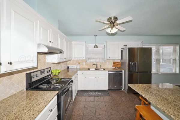 a kitchen with a stove a sink and a refrigerator