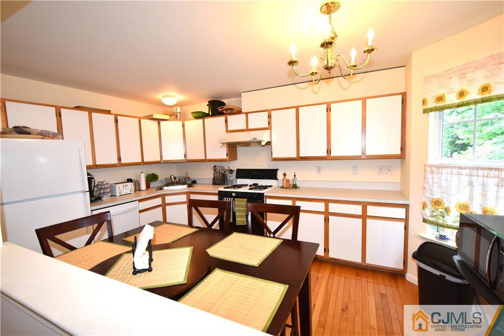 248 Hawthorne Road North Brunswick, NJ 08902 - Photo 10 of 24 a kitchen with a table chairs stove and wooden floor